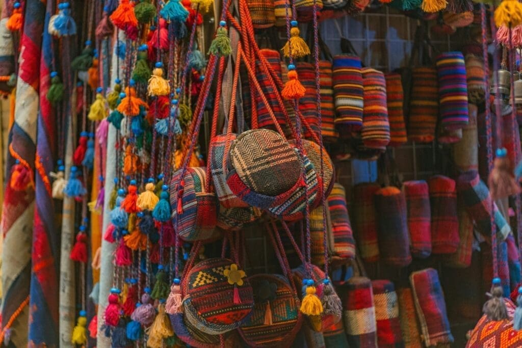 Colorful woven bags and patterned fabrics hanging at an East Africa market stall