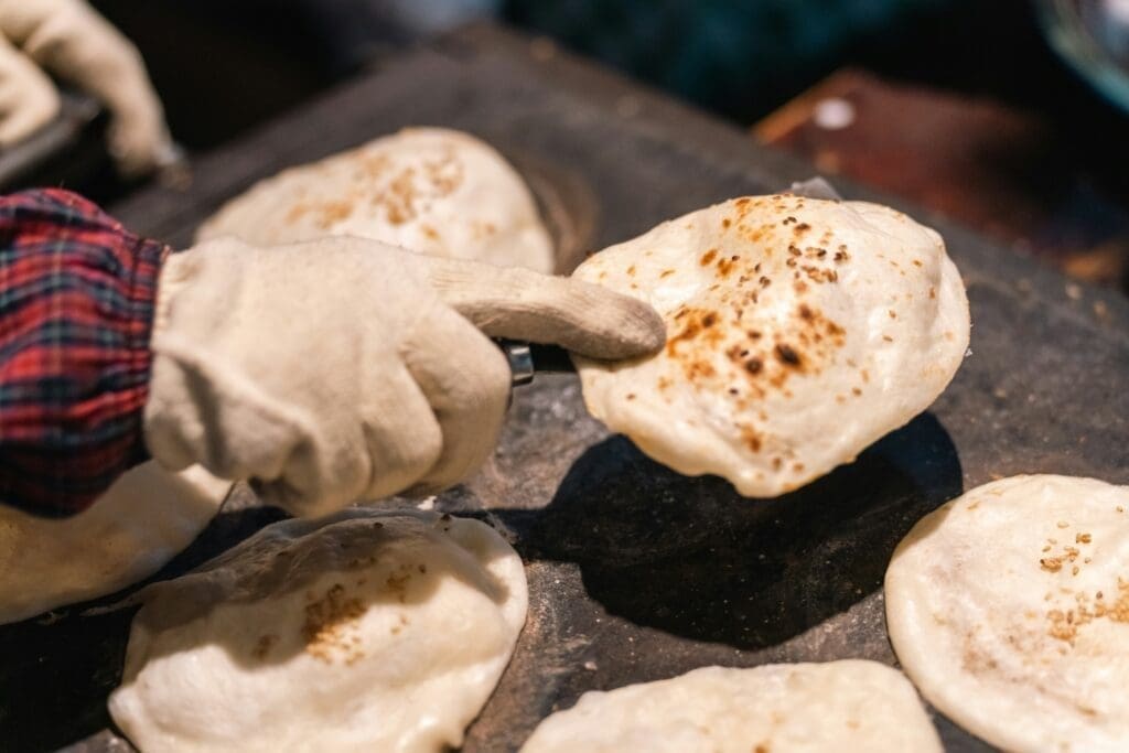 Chapati cooking on a flat pan over open flame in an East Africa street kitchen