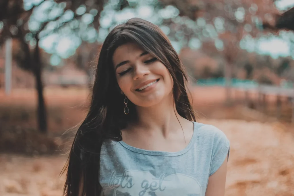 Young woman smiling with her eyes closed, radiating a calm and content expression.