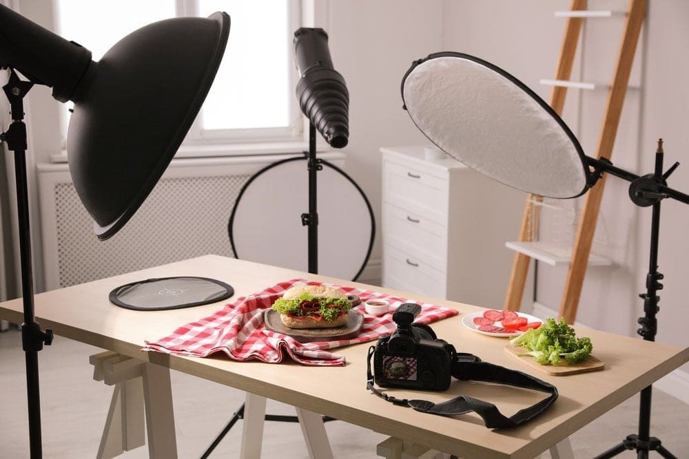 Different light sources used in a small kitchen, including an LED panel, ring light, diffused desk lamp, and window light.
